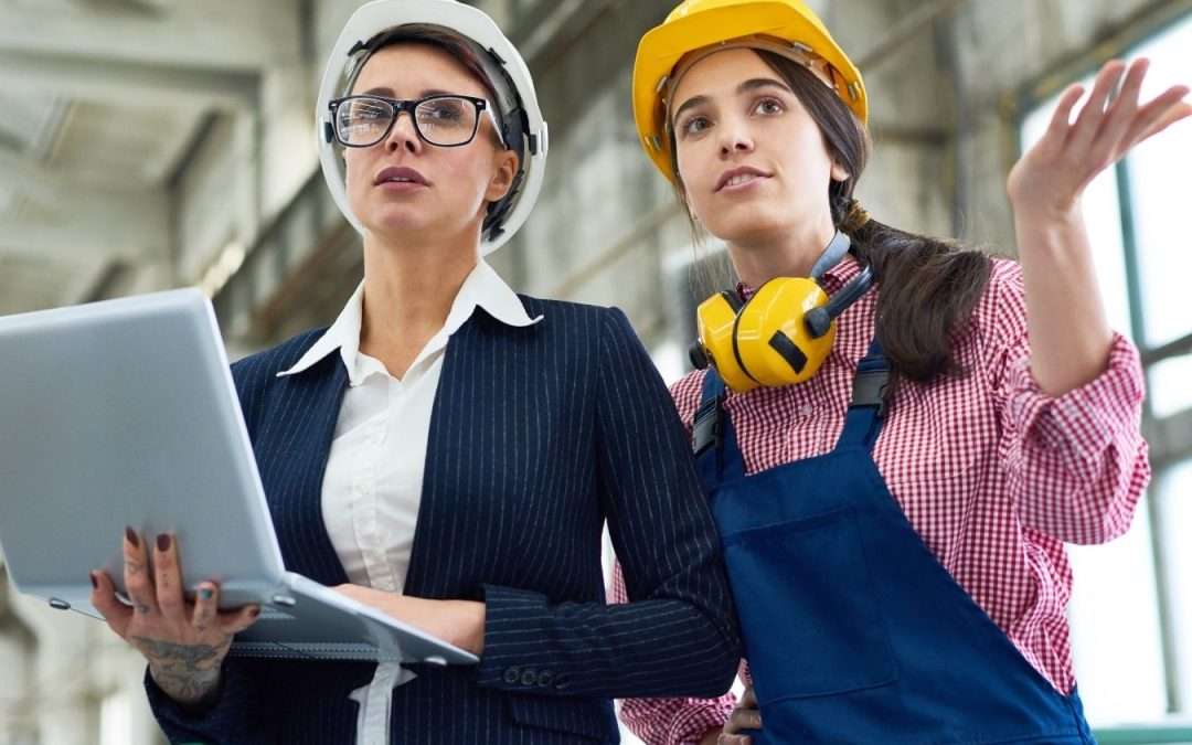 manufacturing owner and employee on factory floor with laptop
