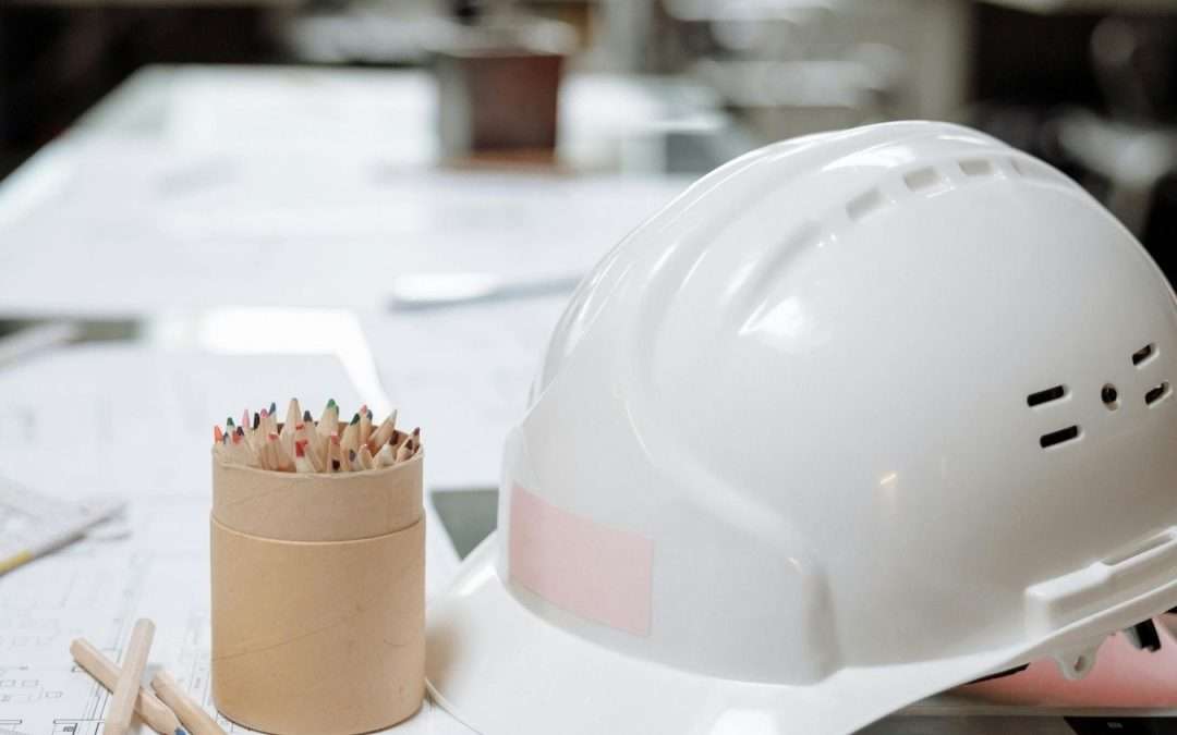 hard hat on desk with pencils